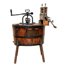 an old fashioned sewing machine sitting on top of a wooden barrel with tools in it