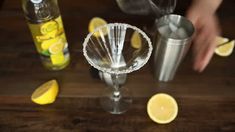 someone is making a drink with lemons on the table