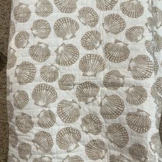 a blanket with shells on it is laying on the floor