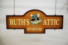 a wooden sign hanging from the side of a wall that says ruth's attic bookstore