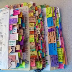 an open book covered in lots of colorful notes and magnets on top of it