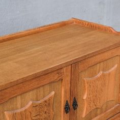 a close up of a wooden cabinet with carvings on the doors and drawer drawers,