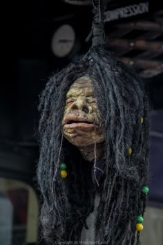 a creepy doll with dreadlocks hanging from the ceiling