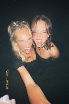 two women are posing for the camera with their arms around each other and one has her mouth open