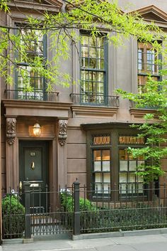 an apartment building with wrought iron fence and green door