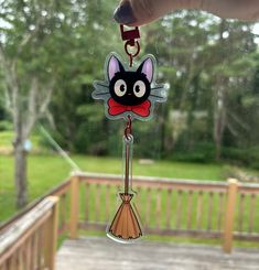 a hand holding a keychain with a cartoon cat on it's face