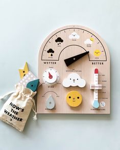 a wooden clock with different items on it and a bag next to it that says how's the weather?