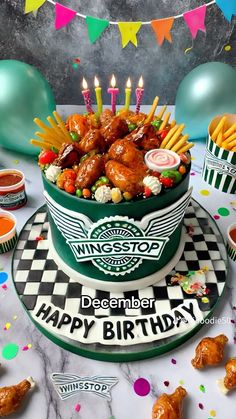 a birthday cake that is sitting on a table with candles in the shape of chicken wings