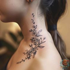 a woman's neck with flowers and leaves tattoo on the back of her neck