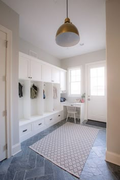 a room that has some white cabinets and a rug on the floor in front of it