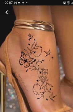 a woman's foot with an owl and butterflies tattoo on it