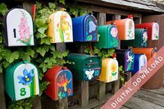 several colorful mailboxes are attached to a wooden fence