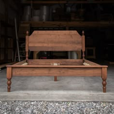 a wooden bed frame sitting on top of gravel