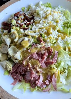 a white plate topped with salad and meat