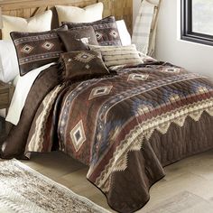 a bed in a bedroom with a brown and white comforter on top of it