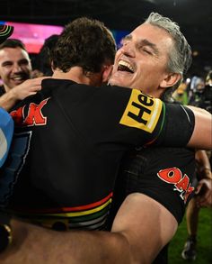 two rugby players hugging each other in the middle of a crowd at a sporting event