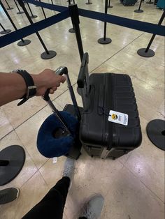 a person is pulling a piece of luggage through an airport baggage claim area with their feet on the ground