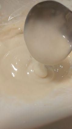 a spoon is being used to mix cream in a bowl