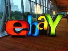 the ebay logo is displayed in front of an office building with large glass windows