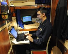 a man sitting at a desk using a laptop computer