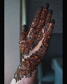 a woman's hand is decorated with hennap and intricate designs on it