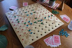 a wooden board game set up on a table with cards and dices scattered around it