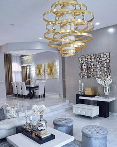 a living room filled with furniture and a large chandelier hanging from the ceiling