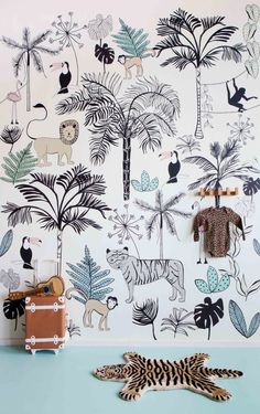 an animal themed wallpaper with jungle animals and palm trees on the wall, along with luggage