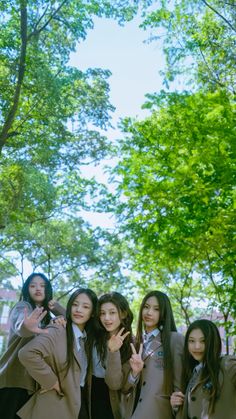 group of young women posing in front of trees