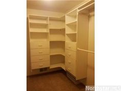 an empty closet with white drawers and shelves