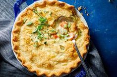 a pie sitting on top of a blue plate next to a knife and fork in it