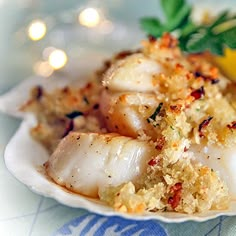 a close up of a plate of food on a table with lemon wedges and parsley