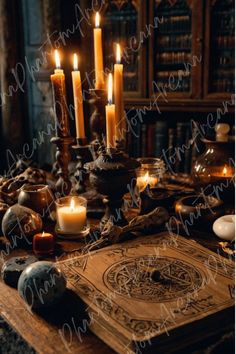 a table topped with lots of candles next to an old book and bookshelf