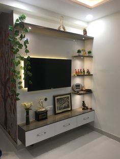 an entertainment center with two shelves and a flat screen tv mounted on the wall above it