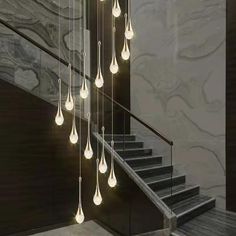 a bunch of lights hanging from the side of a stair case next to a set of stairs