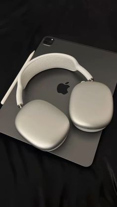 an apple computer mouse and headphones on a black surface