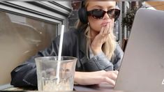 a woman wearing headphones and using a laptop