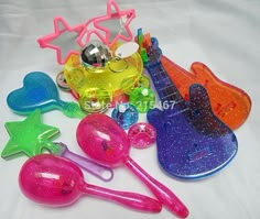 colorful plastic utensils are laying on a white sheet with stars and guitars in the background