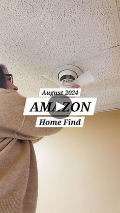 a woman is looking at the ceiling fan in her home finder's office