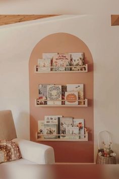 a living room filled with furniture next to a wall mounted book shelf covered in books