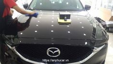 a man waxing the hood of a black car