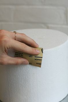 a woman's hand on top of a roll of toilet paper