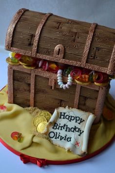 a birthday cake made to look like a pirate's chest with candy and coins