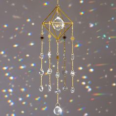 a gold and crystal wind chime hanging from a ceiling with bubbles in the background