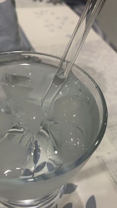 a glass bowl filled with water sitting on top of a white and blue table cloth