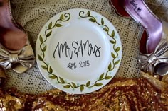 a plate with the name mr and mrs on it sitting next to some silver shoes