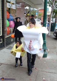 a woman and child are walking down the street in costumes that look like they're holding hands with each other