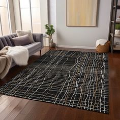 a living room area with a couch, chair and rug on the hardwood flooring