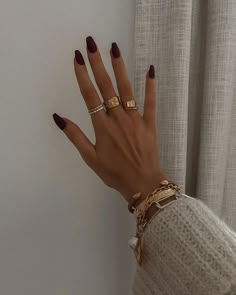 a woman's hand with two gold rings on her left and one ring on her right