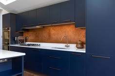 a kitchen with blue cabinets and white counter tops